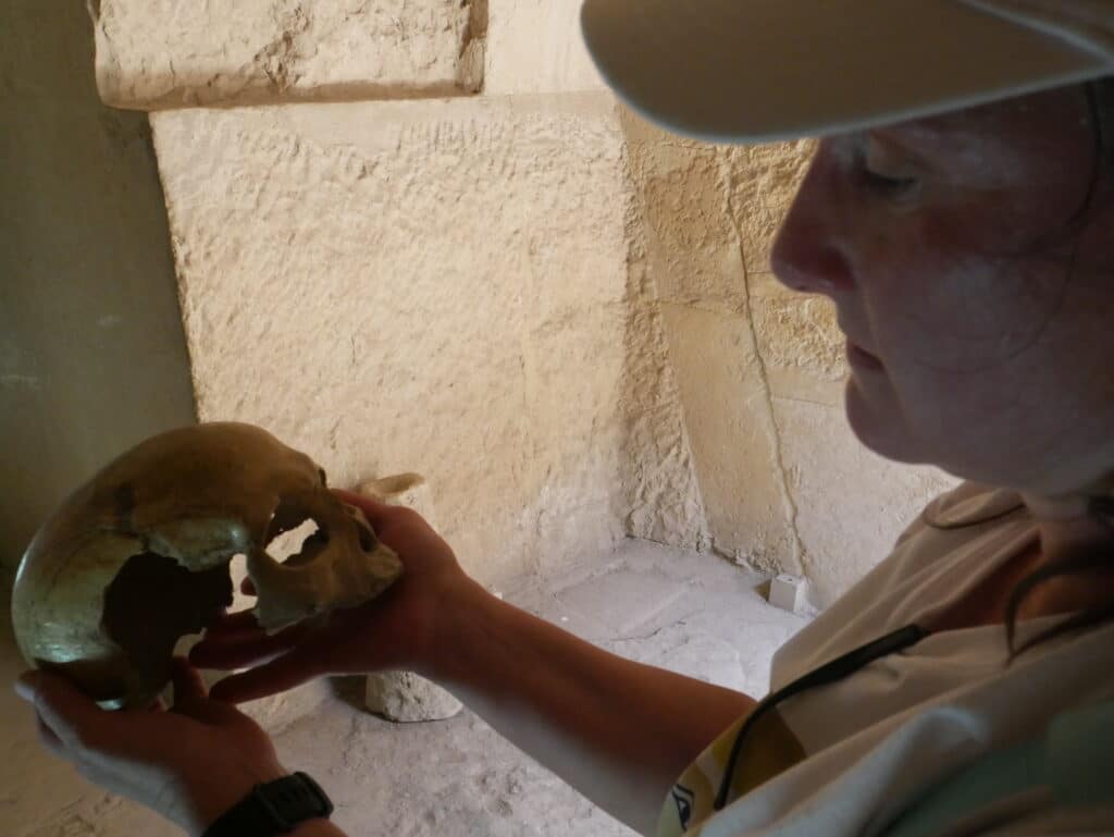 holding ancient skull at the Egyptian Pyramids